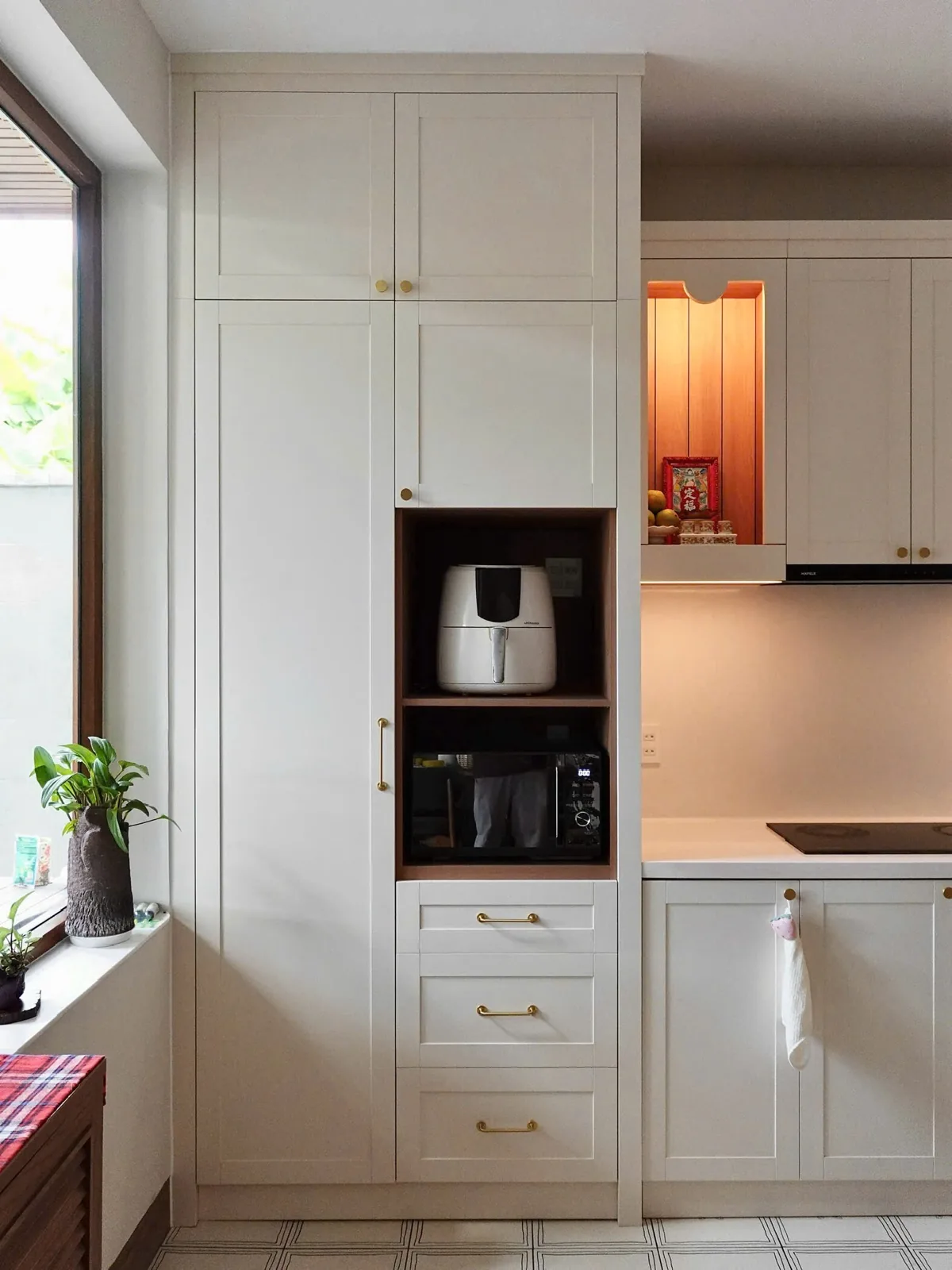 Hệ tủ kho kịch trần với các hộc tủ được đo đạc chuẩn xác, ôm khít các thiết bị điện tử như lò vi sóng, nồi chiên không dầu.